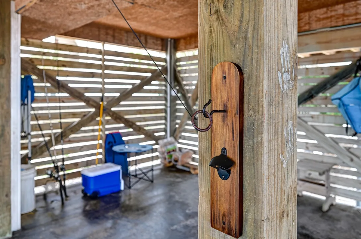 A cozy, organized nook with a wooden hook holding fishing gear, a cooler, and a folding chair, all ready for a day of adventure. The scene evokes preparation for group activities like fishing, picnicking, or beach outings.
